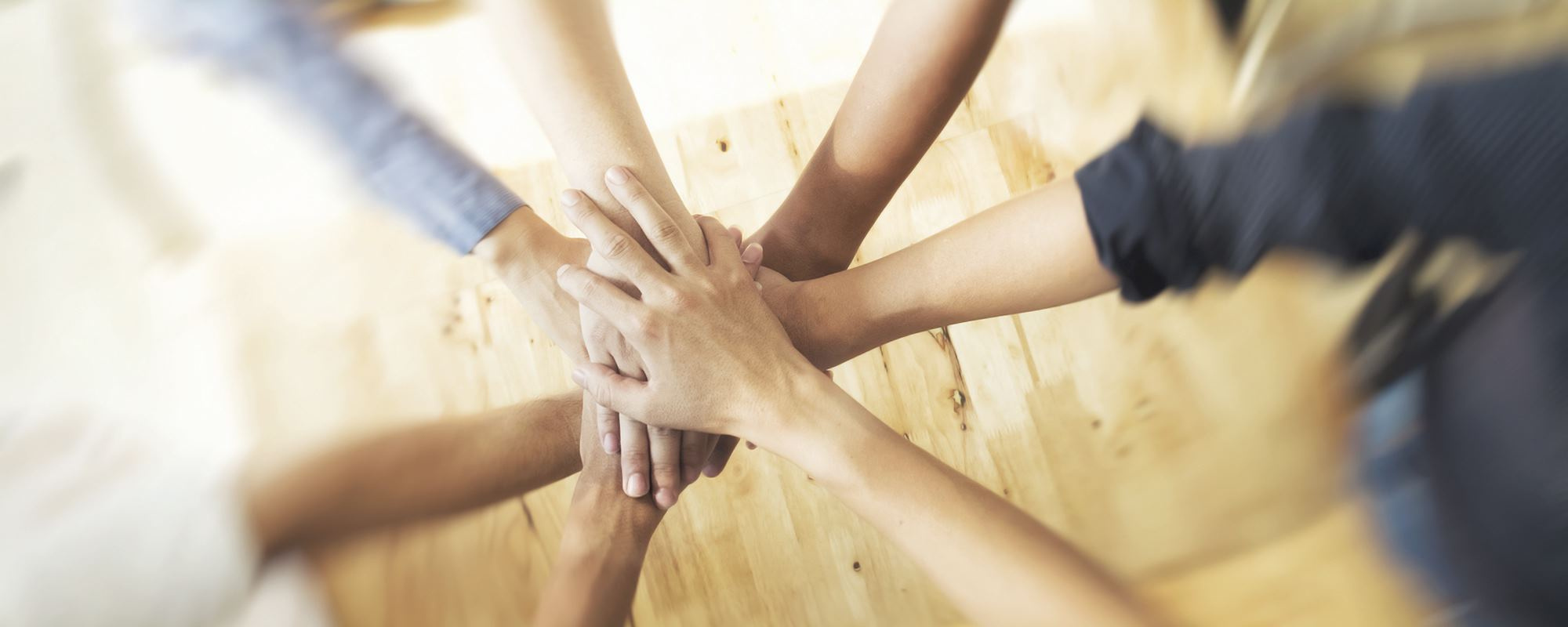 Kuvassa käsiä jotka on tuotu yhteen yhteistyön merkiksi